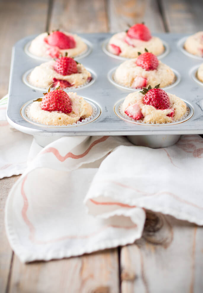 Soft and tender, playful and joyful, quick and easy strawberry coconut muffins. The perfect way to start your day or enjoy all day long. Light on sugar, filled with a delicious combination of sweet strawberries and shredded coconut!