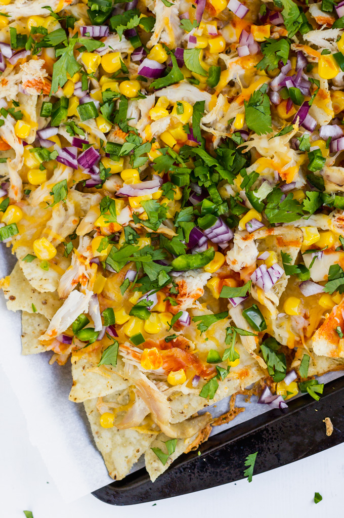 Quick and easy rotisserie chicken nachos recipe. In this post, you will learn how to make chicken nachos with rotisserie or any cooked shredded chicken. This is lighter nachos where I omitted heavy cheese sauce. Instead, I used only cheese and hot sauce to create healthier buffalo chicken nachos recipe. #nachos #chickennachos #rotisseriechicken