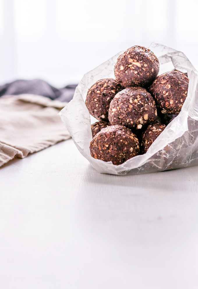 This easy to make, no bake chocolate energy balls recipe is vegan, gluten-free and refined sugar-free. No baking is required! Simply put all ingredients in a food processor, and after a couple of pulses, you have a perfect healthy snack to keep you awake throughout the day and weeks. These healthy energy balls are made with dates, nuts, coconut, cacao and some extra nutritious add-ons. Once you learn how to make energy balls, you will never buy one again. #energyballs #enerybites #energybars