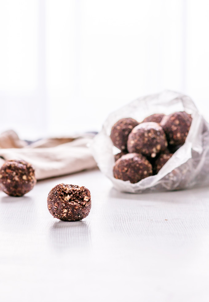 This easy to make, no bake chocolate energy balls recipe is vegan, gluten-free and refined sugar-free. No baking is required! Simply put all ingredients in a food processor, and after a couple of pulses, you have a perfect healthy snack to keep you awake throughout the day and weeks. These healthy energy balls are made with dates, nuts, coconut, cacao and some extra nutritious add-ons. Once you learn how to make energy balls, you will never buy one again. #energyballs #enerybites #energybars
