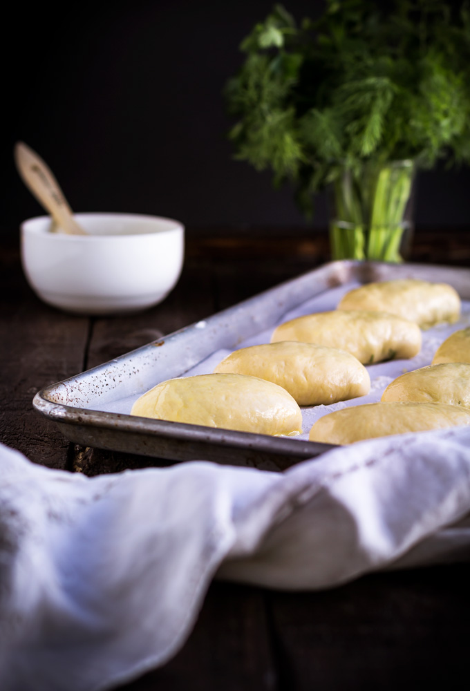 In this post, you will learn how to make authentic Ukrainian piroshki recipe. In English- fresh herbs, egg and rice vegetarian hand pies. Piroshki, pirozhki, pyrizhky are both sweet and savory hand pies made from yeasted dough and are an essential part of the Ukrainian and Russian cuisine. This is the family best piroshki recipe, and I’m very excited to share it with you. And as always in the post, I share some tips and tricks on how to make piroshki from scratch. #piroshki #handpies #savoryhandpies