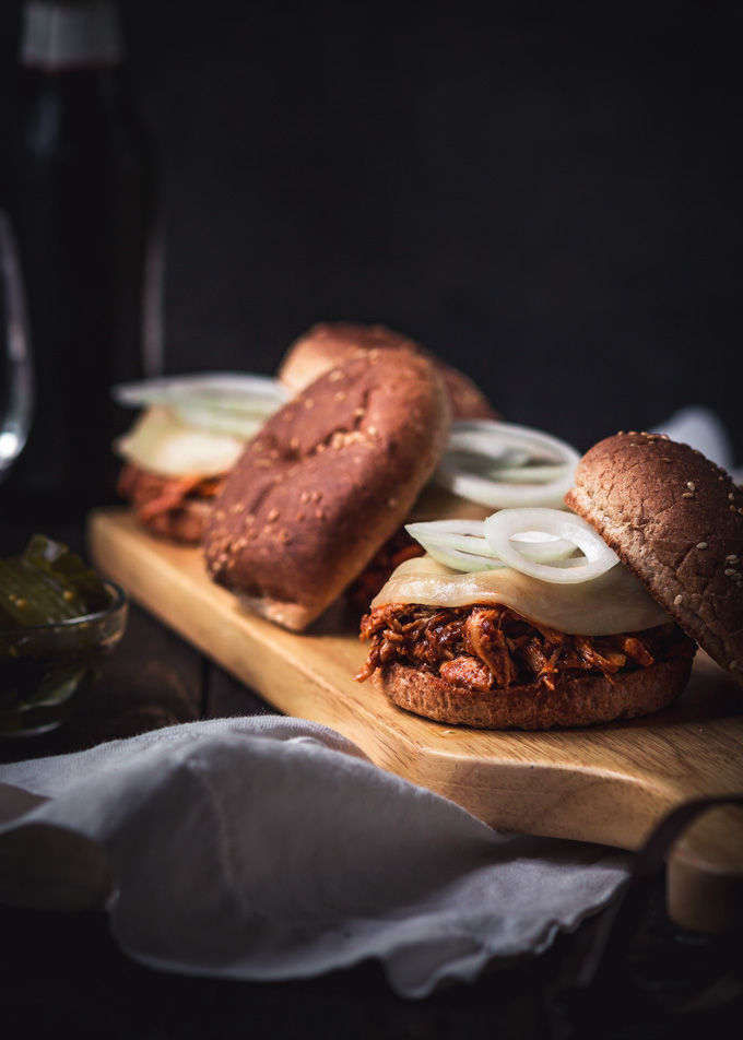 Amazing bbq chicken sliders recipe. These pulled chicken sliders consist of two parts: the homemade BBQ sauce and bbq shredded chicken. Both recipes included. Soft slightly toasted whole wheat buns. Creamy, chewy cheese. And a thinly sliced onion. All of these layers combined create the best chicken sliders. Instant pot chicken sliders are a delicious and easy way to feed a crowd! Or a great finger food dinner to enjoy with friends and family. #bbq #chicken #sliders #burger