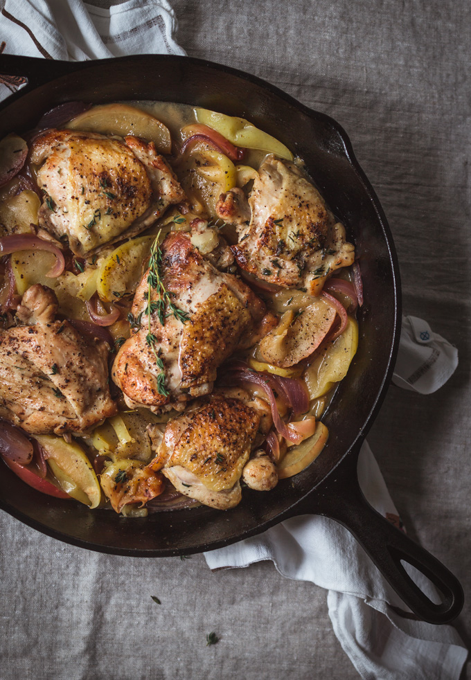 This easy one-pan apple chicken thighs is a healthy, comforting and delicious dinner to make any time of the year, especially in fall. All you need is one skillet, fresh produce, flavorful wine, and thyme. And in about 30 minutes you a have a simple yet delightful apple chicken dinner. Perfect for busy weeknight meals. Serve it with rice or your favorite grains. #chicken #dinner #chickenrecipe #apples #healthy