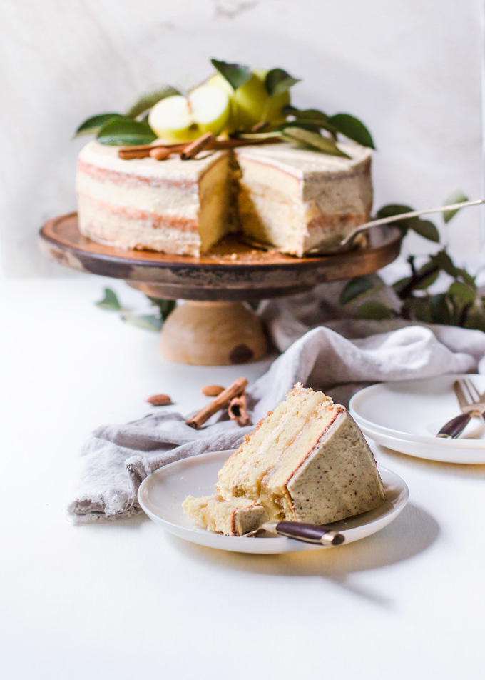 This lighter apple layer cake with whiskey almond frosting is a true fall celebration. It is made with layers of light and airy genoise (sponge) cake with light whiskey scented cream in between and an aromatic apple filling! This can be a Thanksgiving apple layer cake, a special occasion layer cake or a cake to celebrate the most flavorful season – autumn. One thing for sure – this apple and almond layer cake steals the show! Truly the best apple layer cake! #cake #apples #apple #dessert #layercake